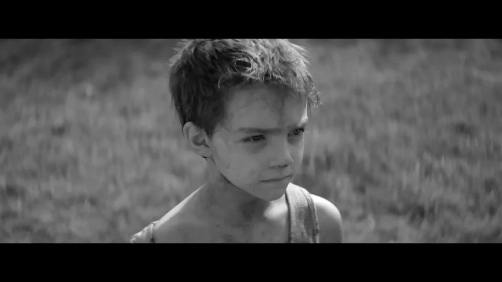 Young boy standing outdoors in Woodkid’s black-and-white film for The Golden Age