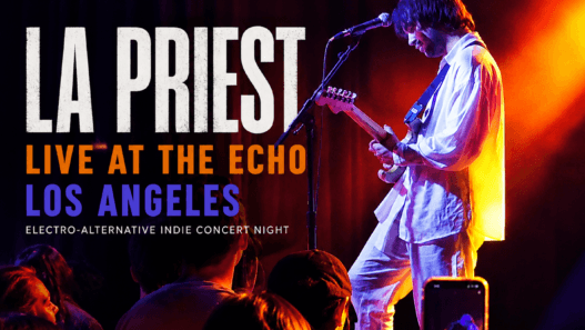 LA Priest performs live at The Echo in Los Angeles during an electro-alternative indie concert night, illuminated by vivid orange and purple stage lights.