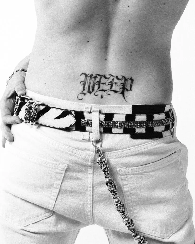 Yungblud photographed from behind with the word weep tattooed across his back