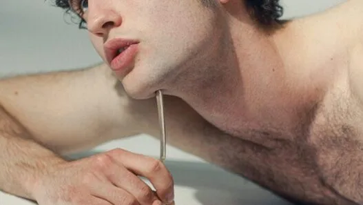 Model Leander Wilde posing with natural hair, rugged charm, and grey eyes.