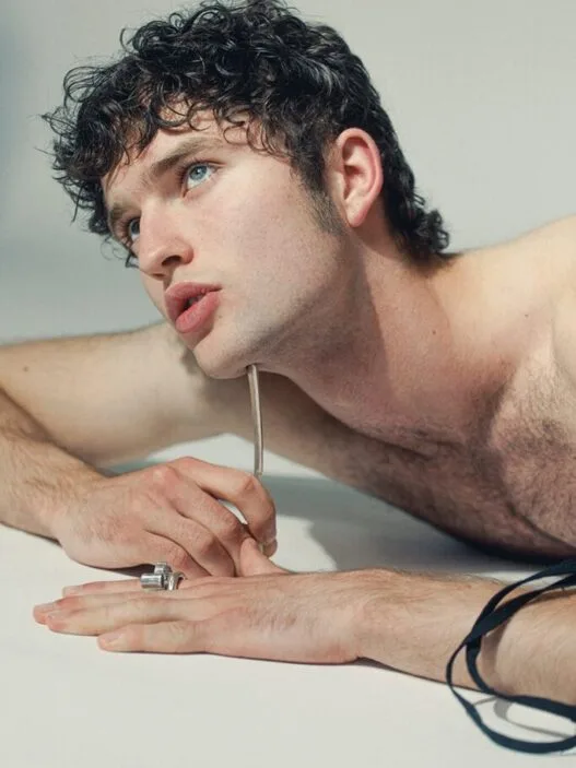 Model Leander Wilde posing with natural hair, rugged charm, and grey eyes.