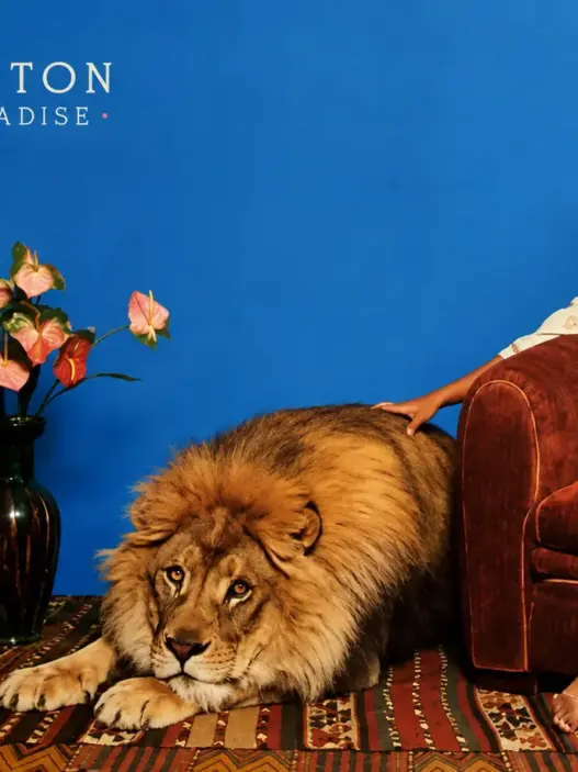 Minnie Riperton seated beside a lion in artwork inspired by her 1975 album Adventures in Paradise