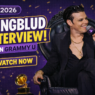 YUNGBLUD speaks on stage during a GRAMMY U interview in 2026, seated in a black armchair and holding a microphone beside GRAMMY trophies.
