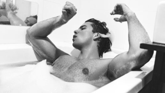 Model Juan Orghici posing in a wet, water‑themed editorial for MMSCENE Style Stories.