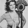Lillian Roth promotional image singing & smiling alongside a vintage microphone