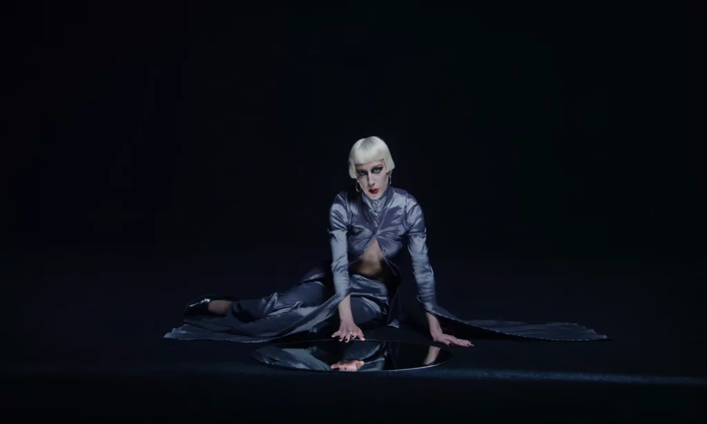 Rare DM Compliment official video still with raw synth-pop energy