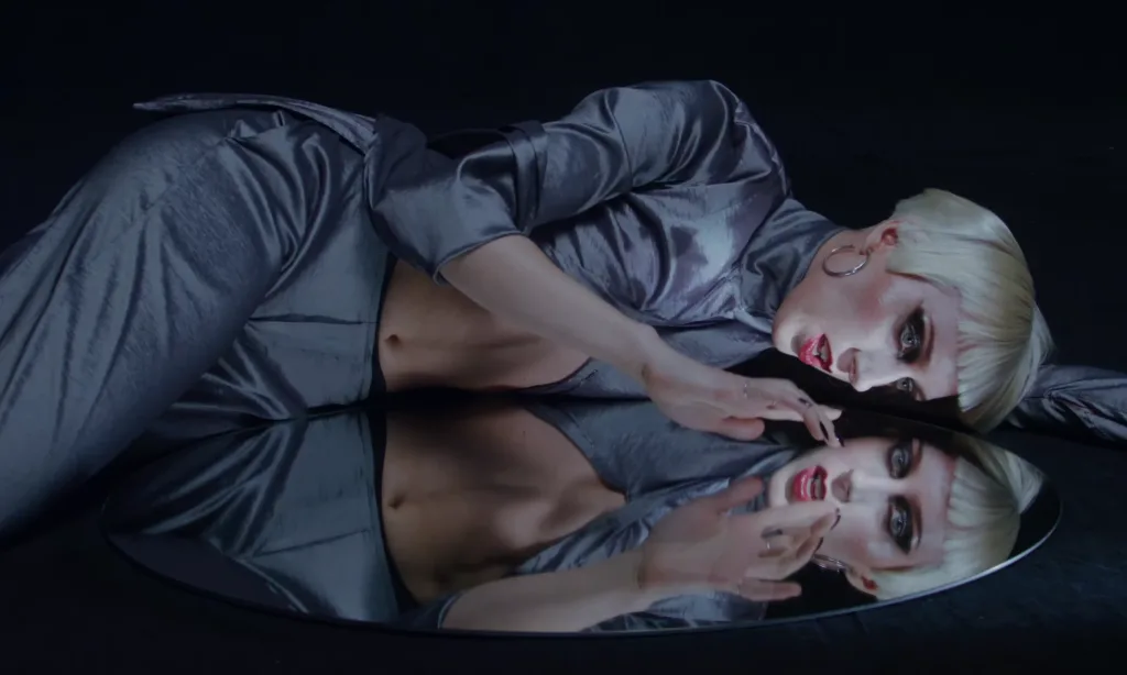 Rare DM in a glam-punk scene from the Compliment music video