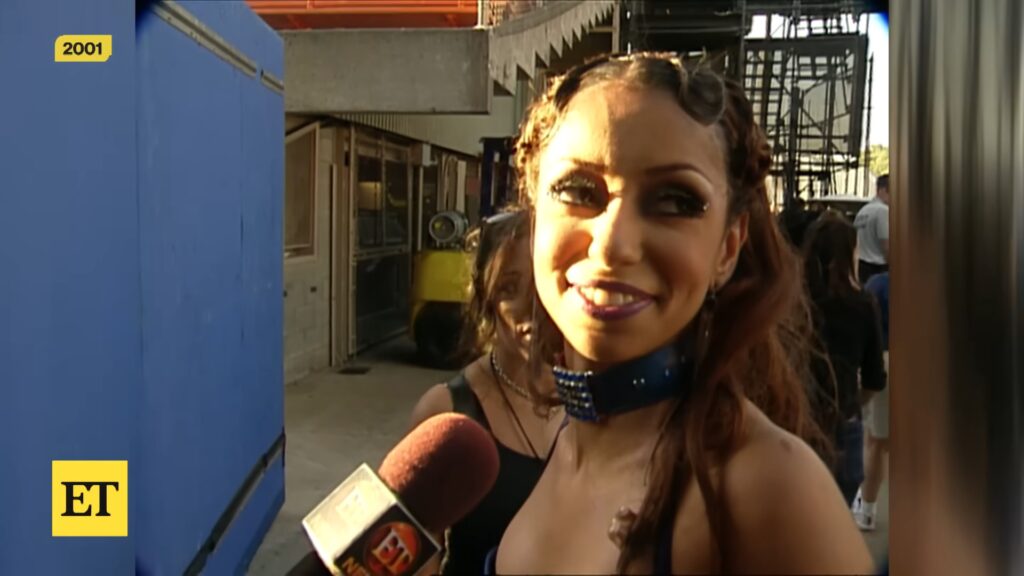 Singer Ma wearing a sparkly blue choker speaks to ET backstage during the 2001 “Lady Marmalade” production.