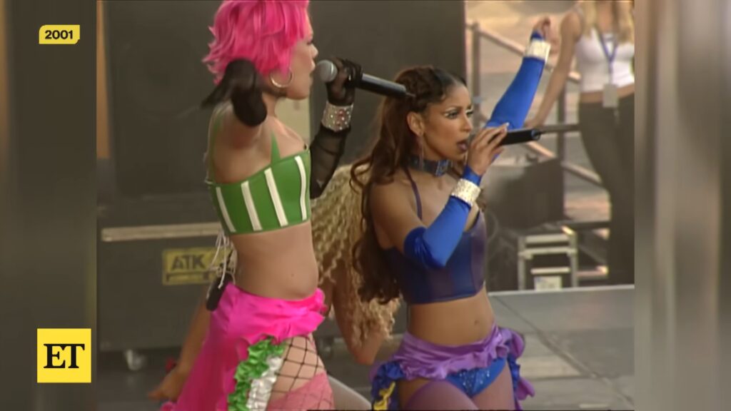 P!nk and Mya sing onstage during a 2001 live “Lady Marmalade” performance, wearing colorful early‑2000s costumes.