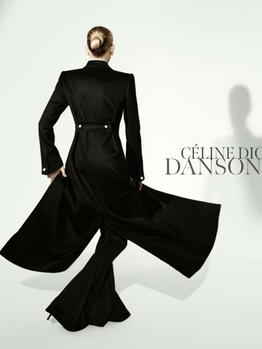Back view of a woman in a long black coat with a flowing cape against a pale background; 'CÉLINE DION DANSONS' text on the right.
