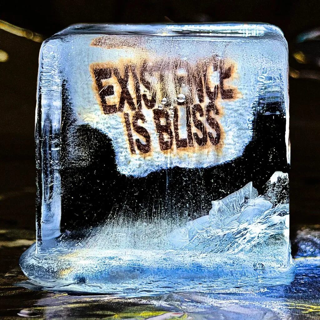 Close-up of an ice sculpture with a burned-in message on its frosted surface, visible in a cool blue glow.