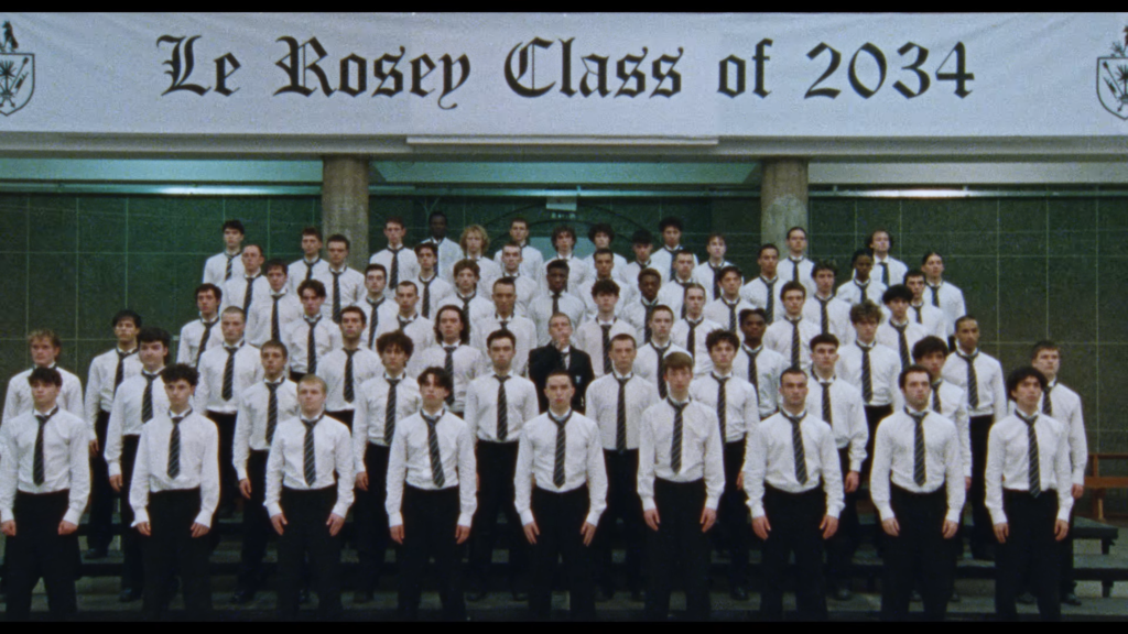 Group of students in white shirts and striped ties posing for a class photo in front of a banner that reads 'Le Rosey Class of 2034'