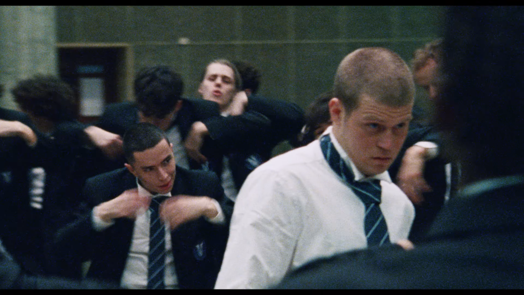 Group of men in dress shirts and striped ties adjusting their ties in a crowded room.