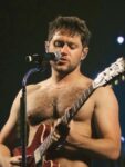 Niall Horan shirtless on stage with guitar