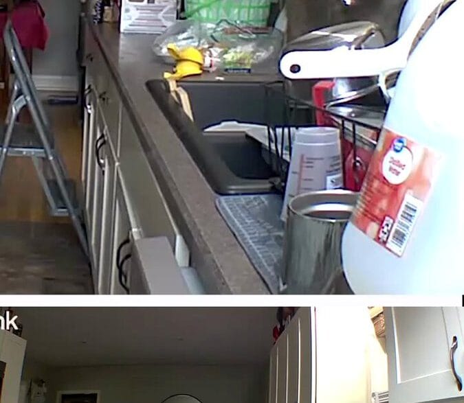 Cluttered kitchen with white cabinets, a stainless sink, a green dish rack, and a step ladder in the center.