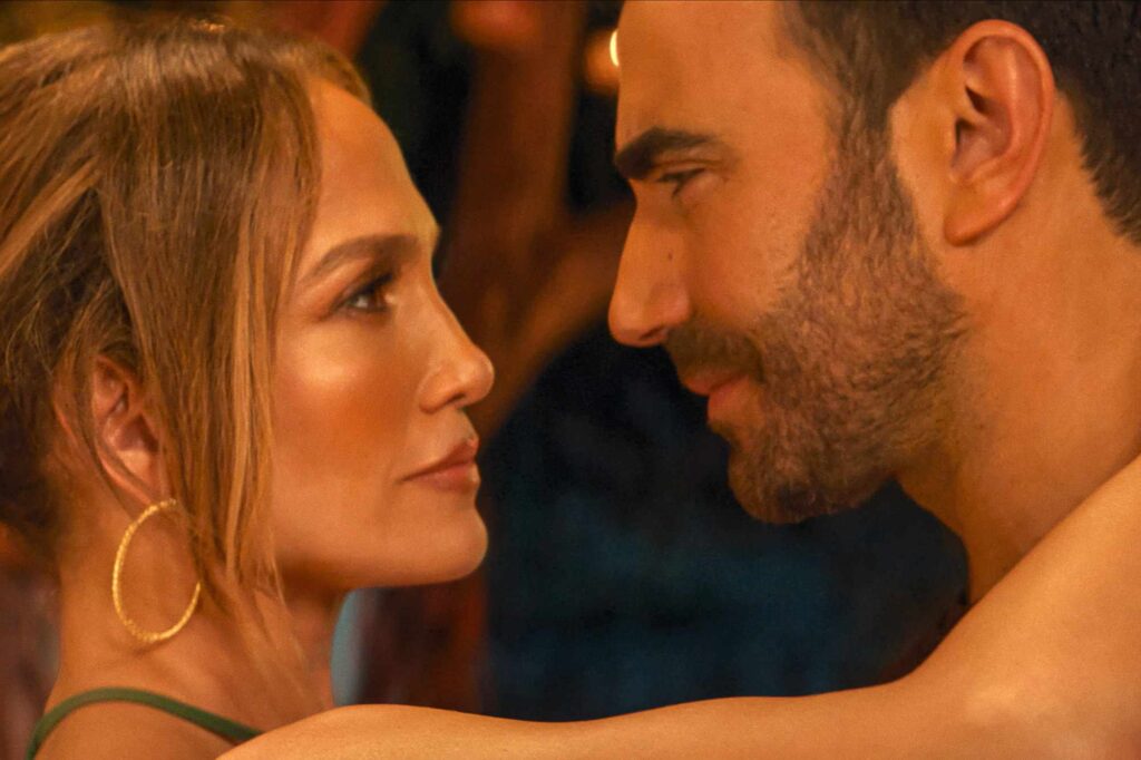 Close-up of a man and woman facing each other, eyes locked, in a warm, intimate moment.