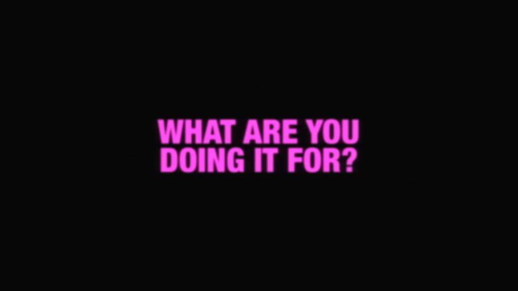 Neon pink text 'WHAT ARE YOU DOING IT FOR?' on a black background, posed as a question.