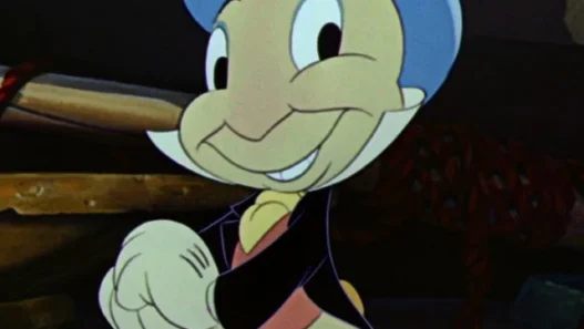 Cheerful Pinocchio-like cartoon boy in a blue hat and yellow shoes, smiling and pointing, while holding a pink umbrella.