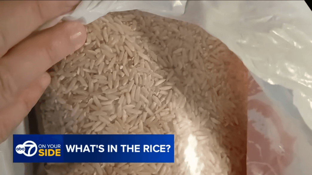 Close-up of a bag of uncooked white rice held in a plastic bag, with a blue ABC7 On Your Side banner reading 'WHAT'S IN THE RICE?'