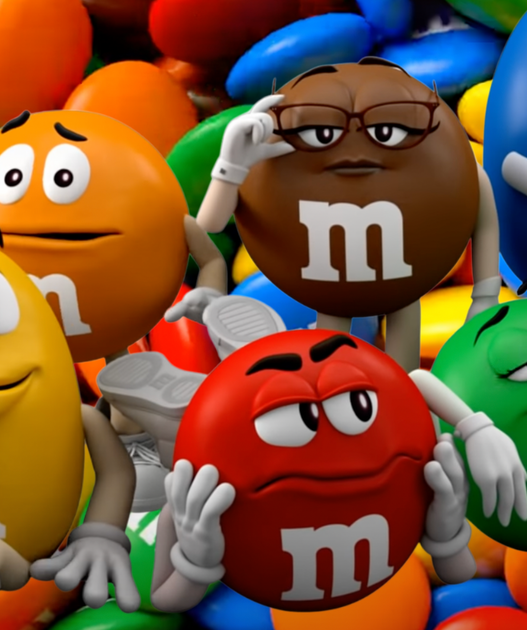 Five anthropomorphic M&M characters posing and lounging on a pile of colorful candies.