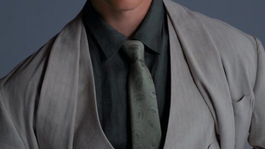 Portrait of a young man in a light gray suit, vest, and paisley tie, wearing a cap and tinted glasses.