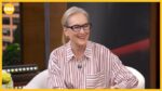 Smiling blonde woman with black glasses in a red-striped shirt on a TV morning-show set (GMA).