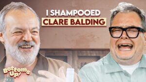 Two men laughing together in a casual setting with the bold headline 'I SHAMPOOED CLARE BALDING' across the top tourbanner style text.