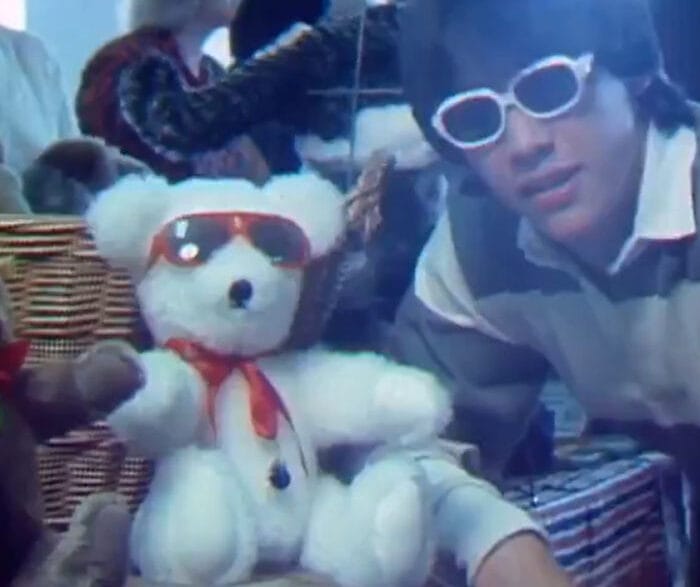Young Keanu Reeves interviewing teddy‑bear collectors as a CBC reporter in a vintage TV segment.