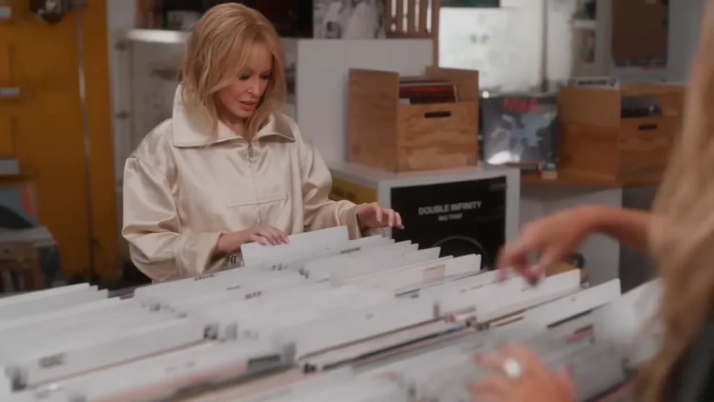 Kylie and Dannii Minogue browsing vinyl records in a Paris record shop