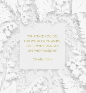 White floral papercut frame surrounds a white card with a gold Christian Dior quote: 'Whatever you do, for work or pleasure, do it with passion! Live with passion!'