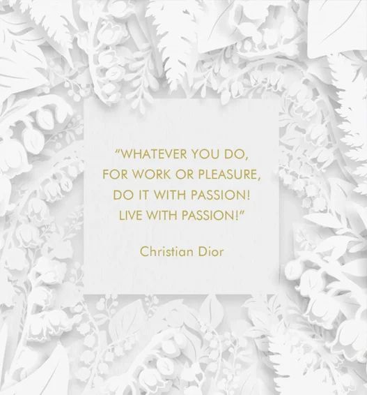 White floral papercut frame surrounds a white card with a gold Christian Dior quote: 'Whatever you do, for work or pleasure, do it with passion! Live with passion!'