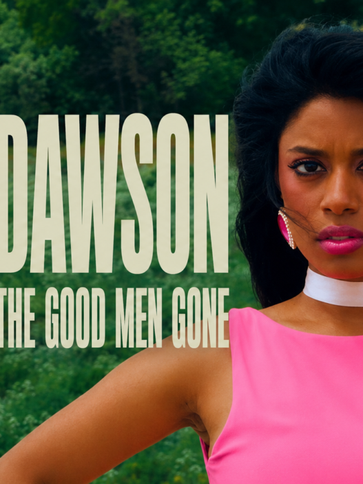 Debbii Dawson stands in a vivid pink dress against a lush green meadow in a cinematic still from “Where Have All The Good Men Gone.”