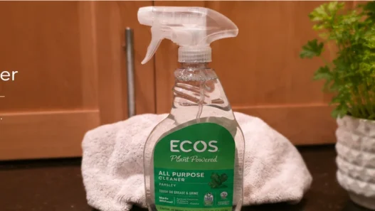 ECOS Parsley All Purpose Cleaner bottle on a kitchen counter with a towel behind it.