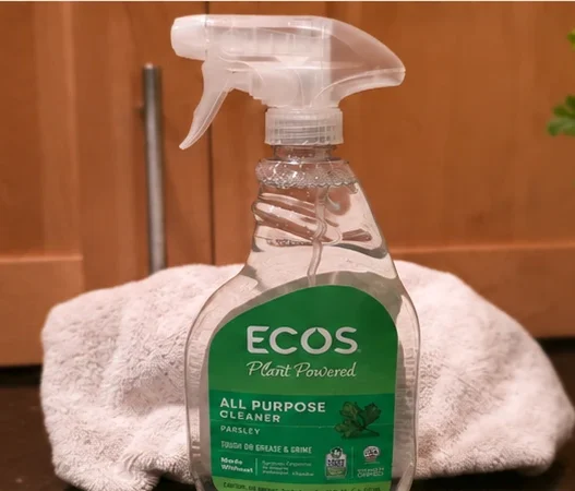 ECOS Parsley All Purpose Cleaner bottle on a kitchen counter with a towel behind it.