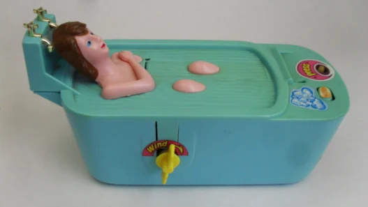 1996 wind‑up beauty‑in‑bath coin‑saving bank, a vintage mechanical collectible.
