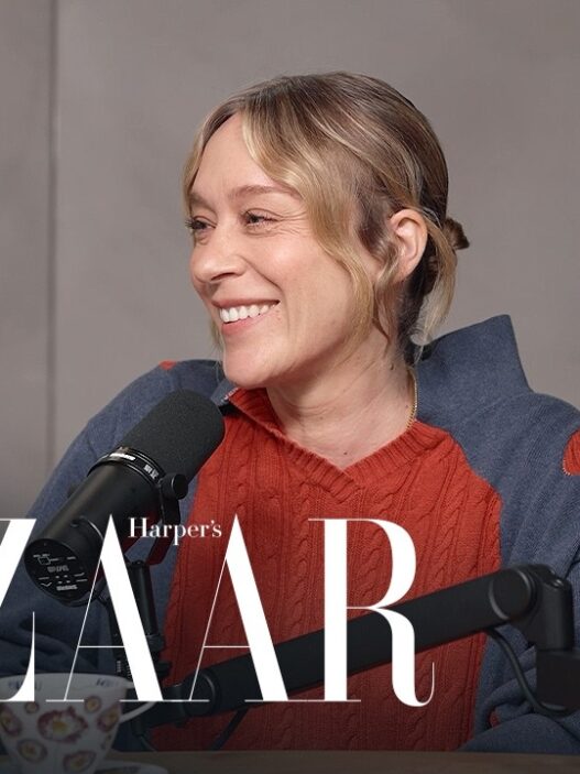 Woman smiling and speaking into a microphone during a podcast interview, with Harper's Bazaar logo overlaid.