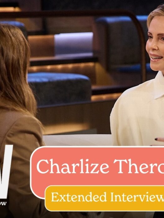 Two women converse on a TV interview set, with a large 'DREW' logo on the left and a peach/yellow overlay announcing an extended interview with the guest.