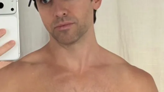 Paul W. Downs posing shirtless in a playful Instagram moment.