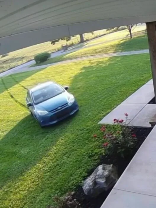 Amazon delivery driver vehicle captured on home security camera driving across a front lawn in Indiana.