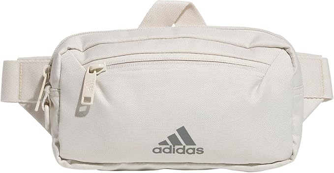 adidas Must Have Fanny Pack in a light neutral color with front zippered pockets.