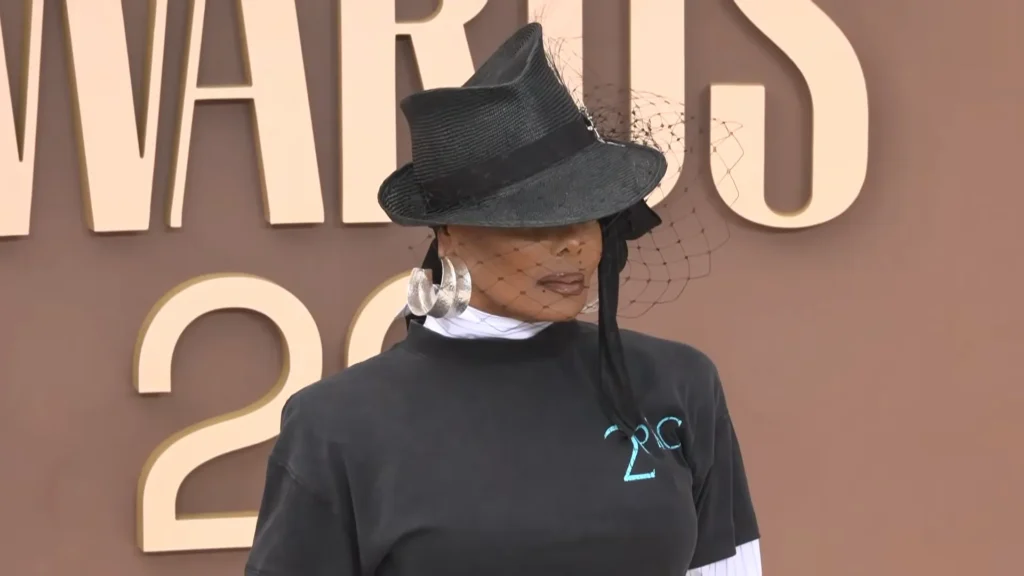 Janet Jackson showing her BET Awards 2026 red carpet look with a veiled fedora
