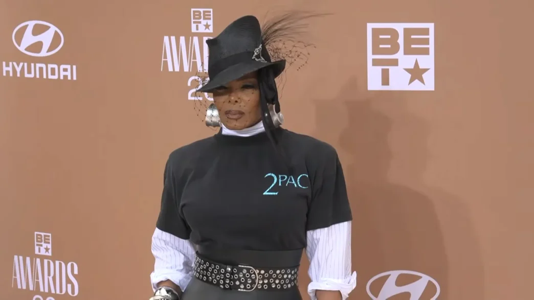 Janet Jackson arriving at the BET Awards 2026 red carpet wearing a vintage Tupac T-shirt and veiled fedora