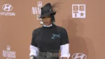 Janet Jackson arriving at the BET Awards 2026 red carpet wearing a vintage Tupac T-shirt and veiled fedora