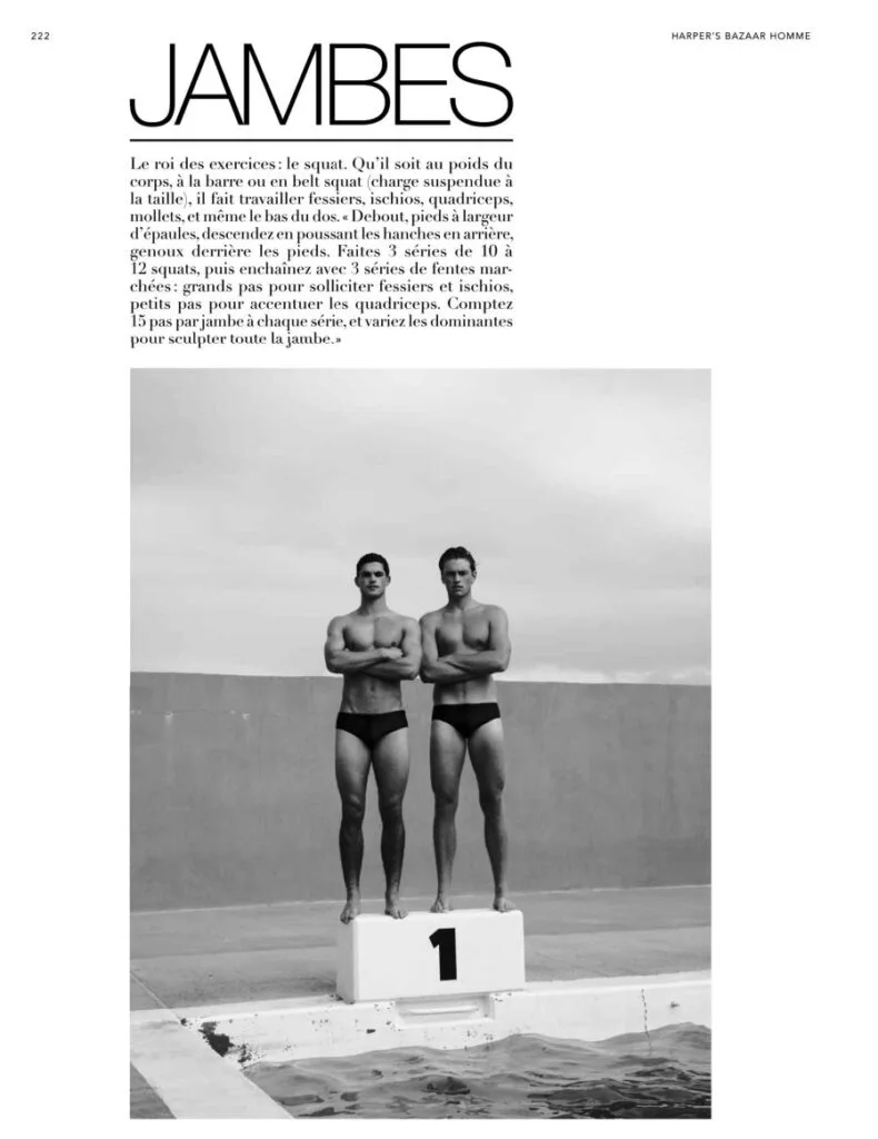 Two Bazaar Sport models in black swim briefs standing on a number-one podium beside a legs workout feature