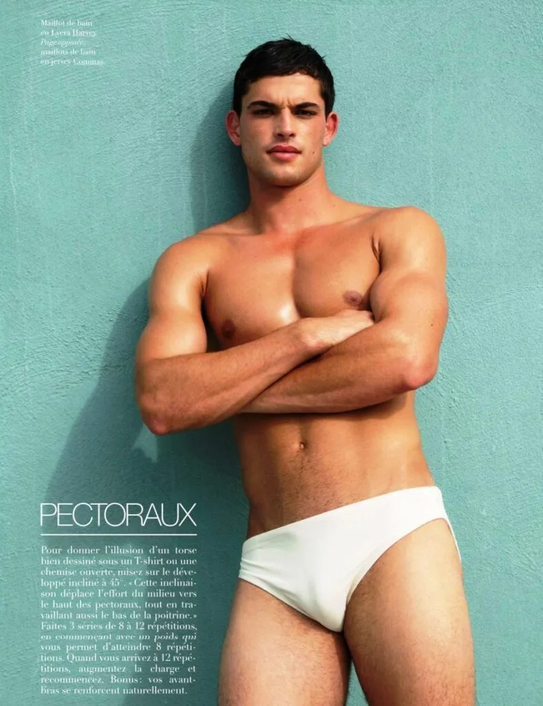 Bazaar Sport model posing in white swim briefs against a turquoise wall for a chest workout feature