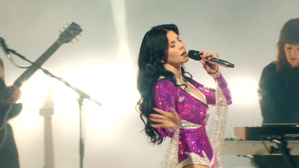 MARINA performs onstage in a sparkling magenta bodysuit with long silver fringe