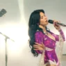 MARINA performs onstage in a sparkling magenta bodysuit with long silver fringe