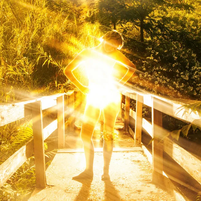 Tele standing on a wooden footbridge surrounded by glowing golden sunlight for the Honesty Project EP artwork