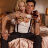 Madonna and Alberto Guerra look toward the camera while reviewing a photograph on the Dolce and Gabbana The One campaign set