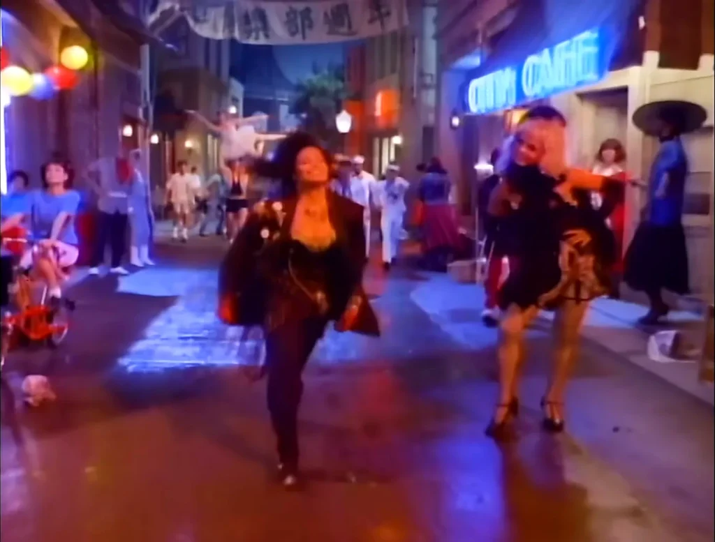 Janet Jackson appears on a colorful neon-lit street in the When I Think of You video